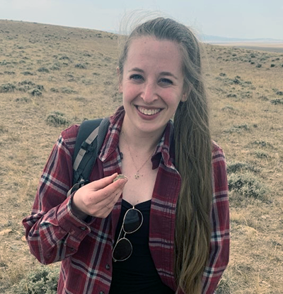 An image of Mason Lee holding a lizard in the field